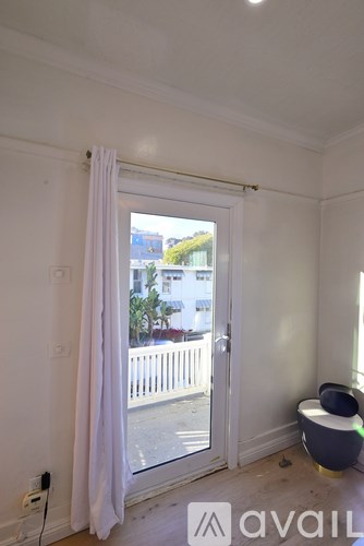 A room with a window and a white curtain.