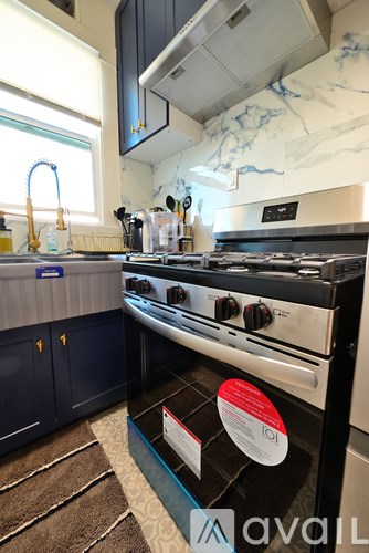 A kitchen with a stove top oven and a window.