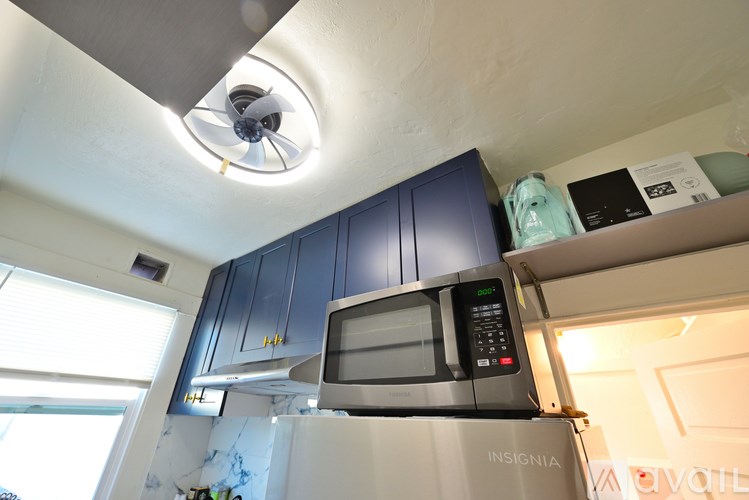A kitchen with a microwave oven on top of a stove.