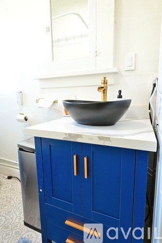 A black bowl sink on a white counter top.