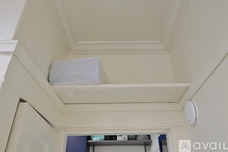 A white ceiling with a vent and a smoke detector.