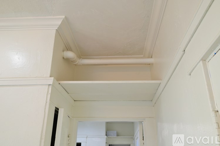 A white ceiling with a pipe running across it.