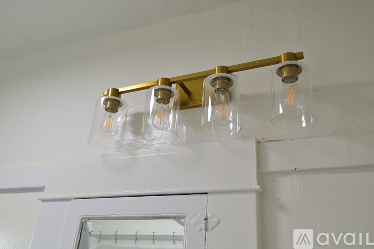 A white cabinet with a gold light fixture above it.