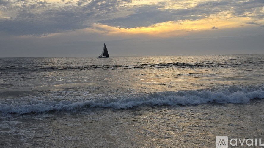 A sailboat is sailing in the ocean during sunset.
