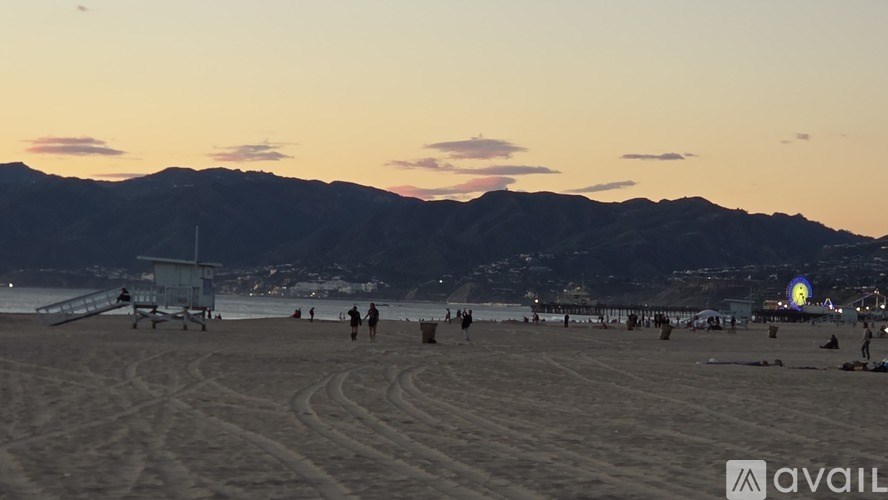 A concrete area with people walking around and a building on the right side.