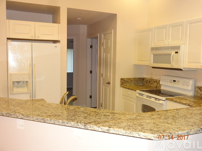 A kitchen with a refrigerator, microwave, oven and stove.