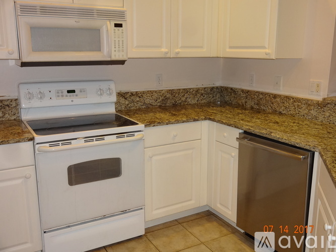 A kitchen with a white oven and microwave.