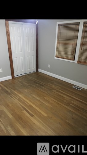 A room with a wooden floor and a white door.