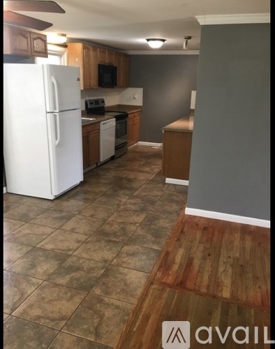 A kitchen with a white refrigerator and wooden cabinets.
