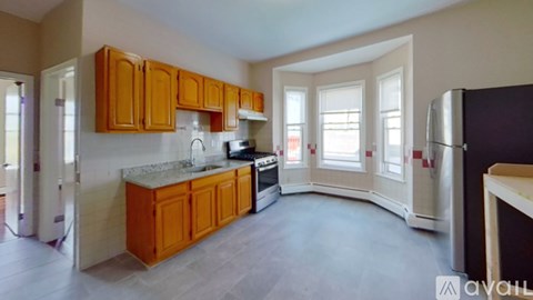 A kitchen with wooden cabinets and a marble countertop.