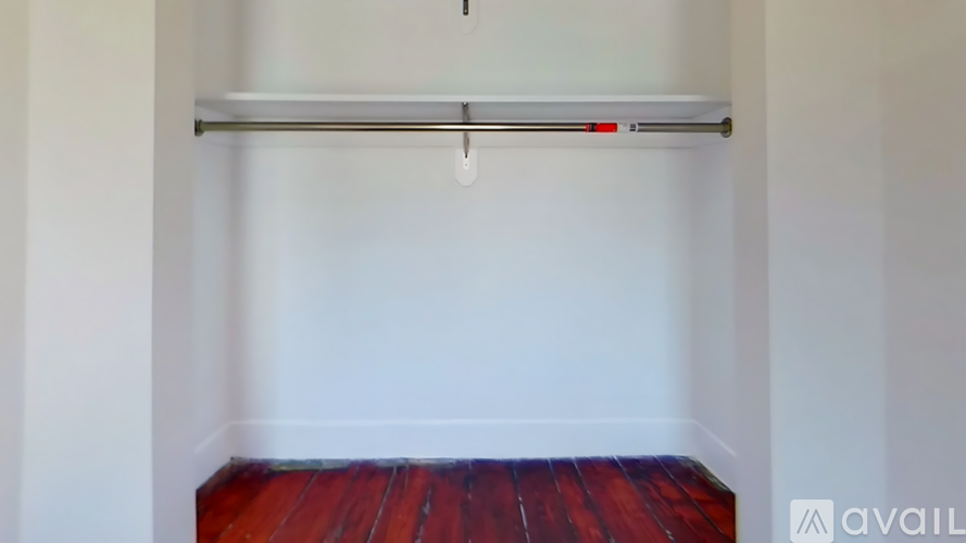A room with a white wall and a wooden floor.