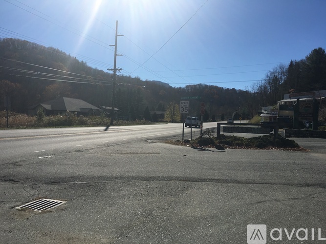 A sunny day at a roadside with a signboard and a pole.