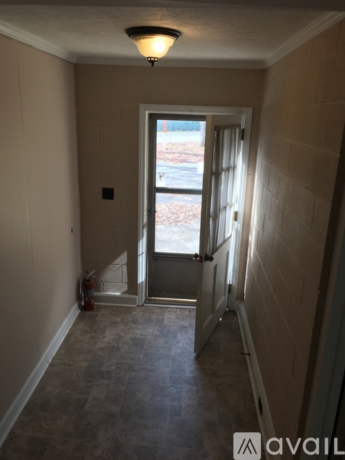 A hallway with a door leading to a balcony.