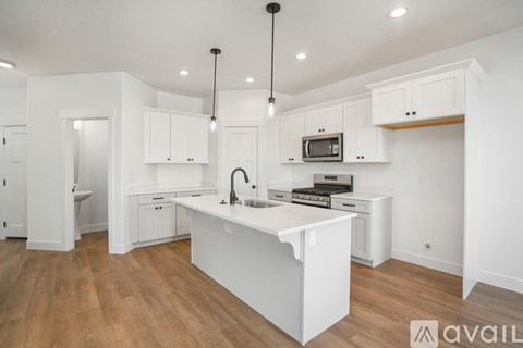 A kitchen with white cabinets and a white island.