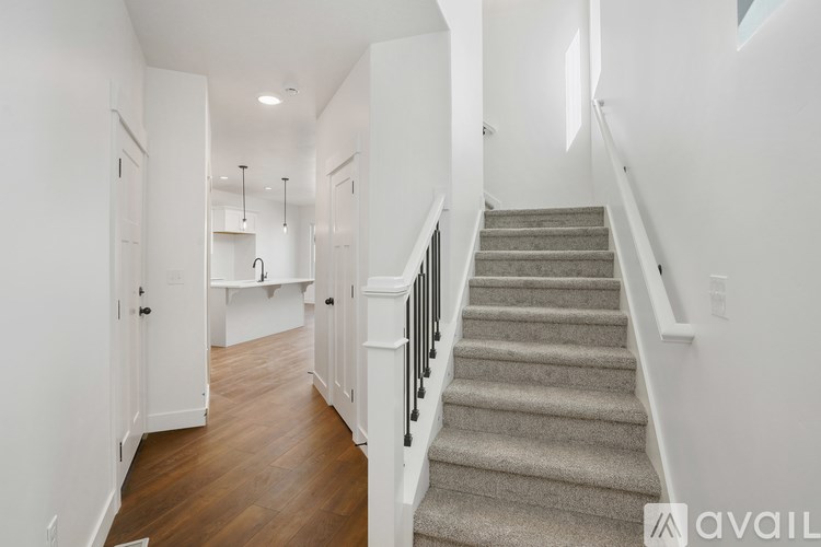 A staircase with a beige carpeted runner and black handrails.