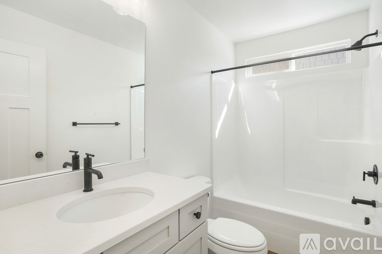 A white bathroom with a sink, toilet, and bathtub.