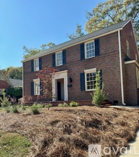 A brick house with a white door and windows.