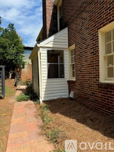 A white house with a brick wall and a window.