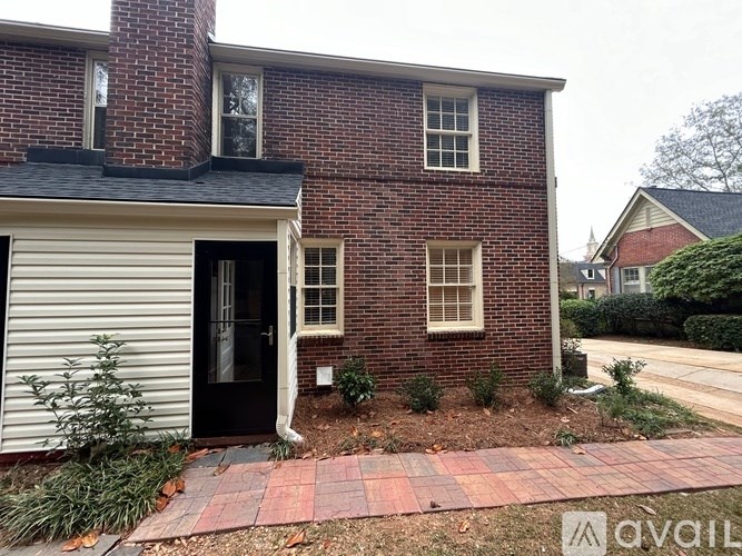 A brick house with a black door and a small window.