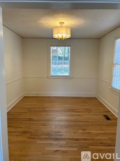 A room with wooden flooring and a window.