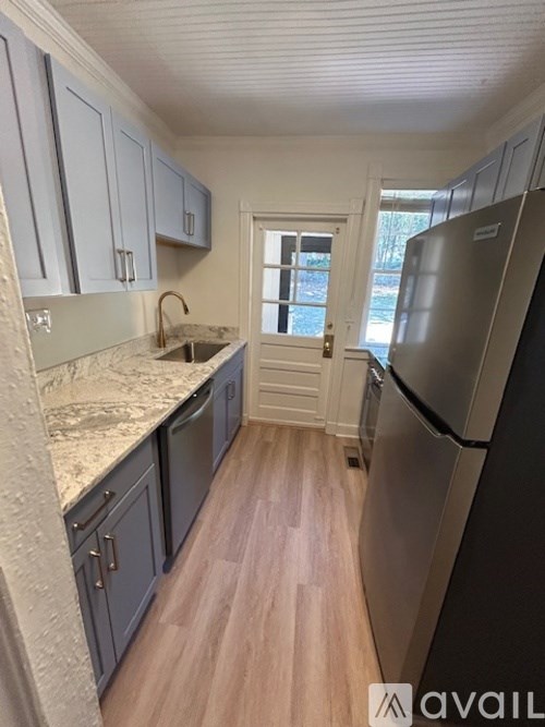A kitchen with a refrigerator on the right side.