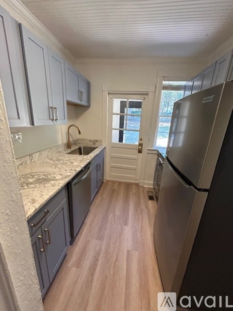 A kitchen with a refrigerator on the right side.