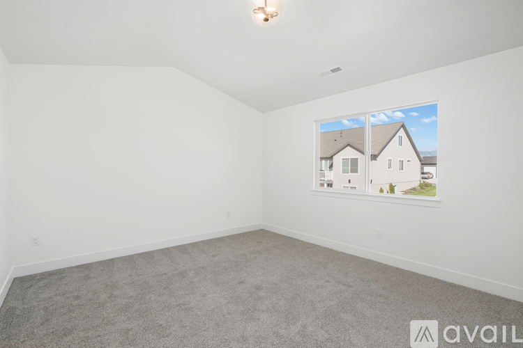 A room with a carpeted floor and a picture of a house on the wall.