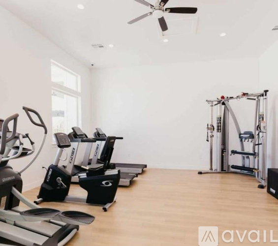 A gym with treadmills, elliptical machines, and a weight machine.