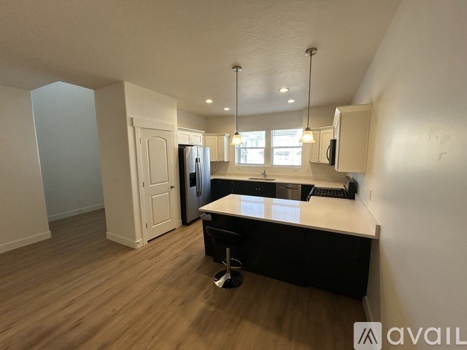 A kitchen with a black countertop and white cabinets.