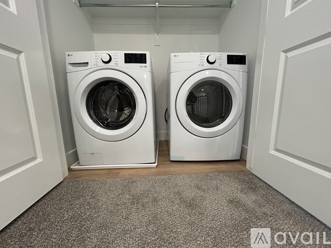Two white front loading washing machines in a small laundry room.