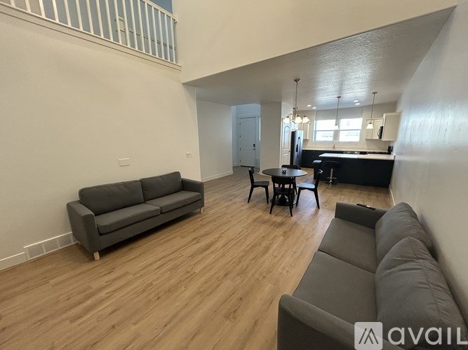 A living room with a grey sofa and wooden flooring.