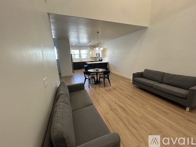 A living room with a grey couch and a black table.