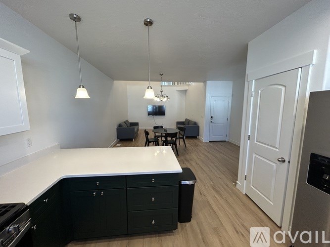 A kitchen with black cabinets and a white countertop is shown.