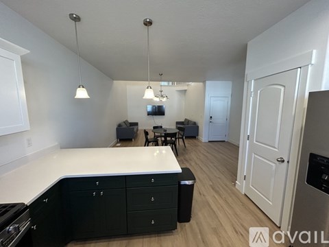 A kitchen with black cabinets and a white countertop is shown.