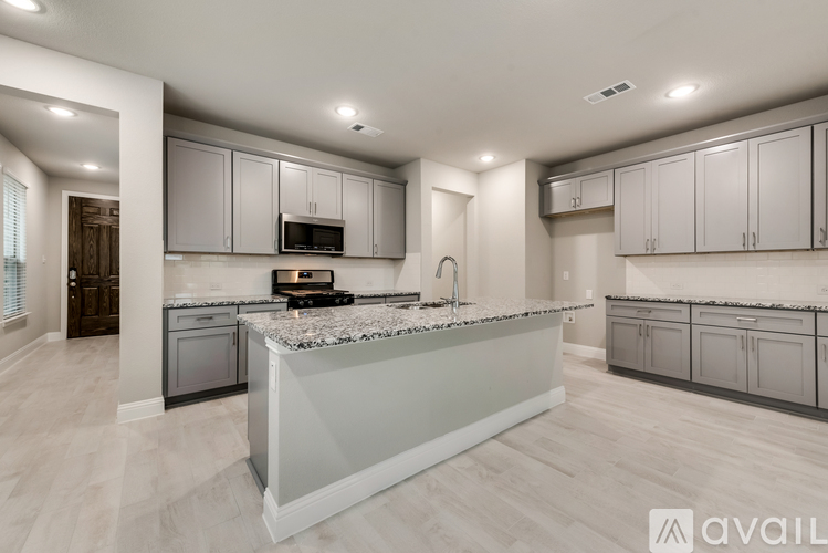 A modern kitchen with a marble island and stainless steel appliances.