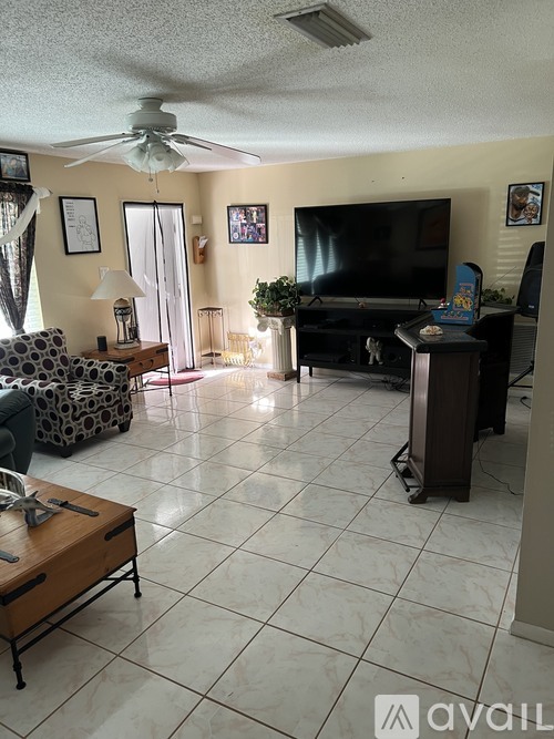 A living room with a television, a couch, and a coffee table.