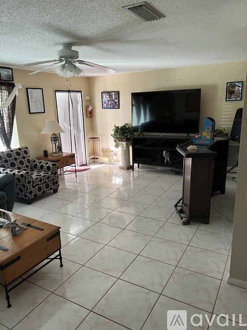 A living room with a television, a couch, and a coffee table.