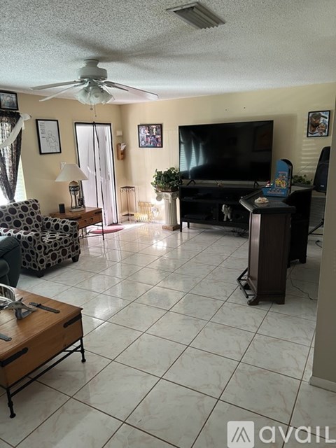 A living room with a television, a couch, and a coffee table.