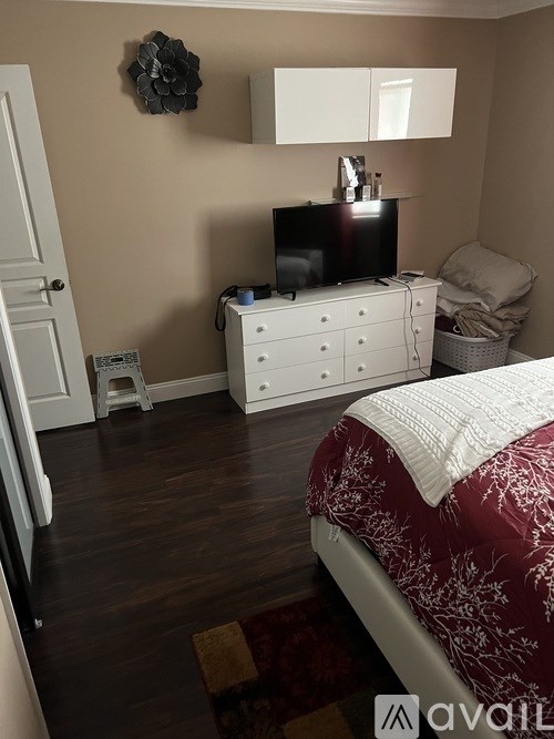 A bedroom with a bed, dresser, and television.