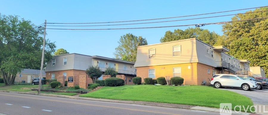 A row of houses with a car parked in front of the first one.
