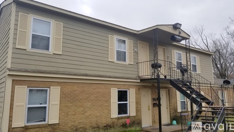 A two-story house with a balcony and a fire escape.