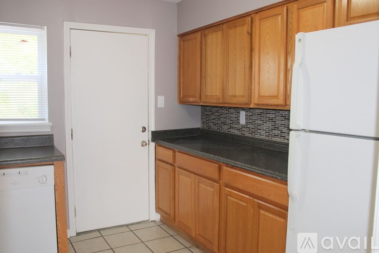 A kitchen with wooden cabinets and a white refrigerator.