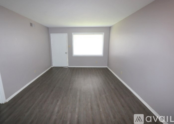 A room with wooden flooring and a window.