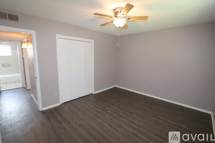 A room with a ceiling fan and a door.