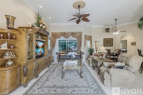 A living room with a large wooden entertainment center and a rug on the floor.