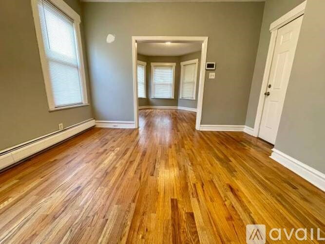 A room with wooden flooring and white walls.