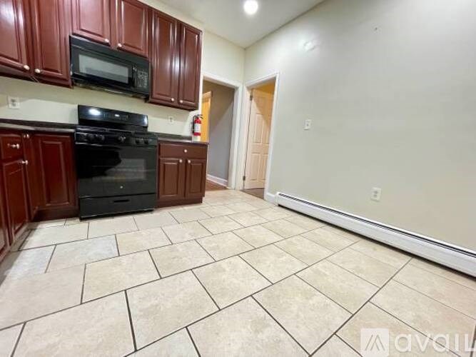 A kitchen with brown cabinets and a black stove top oven.