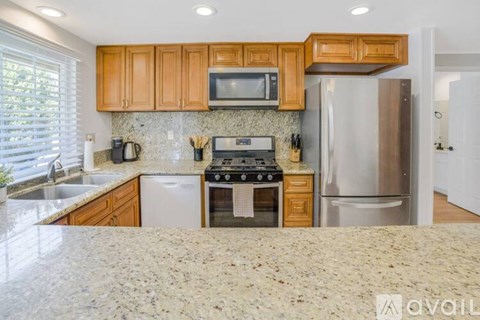A kitchen with wooden cabinets and granite countertops.