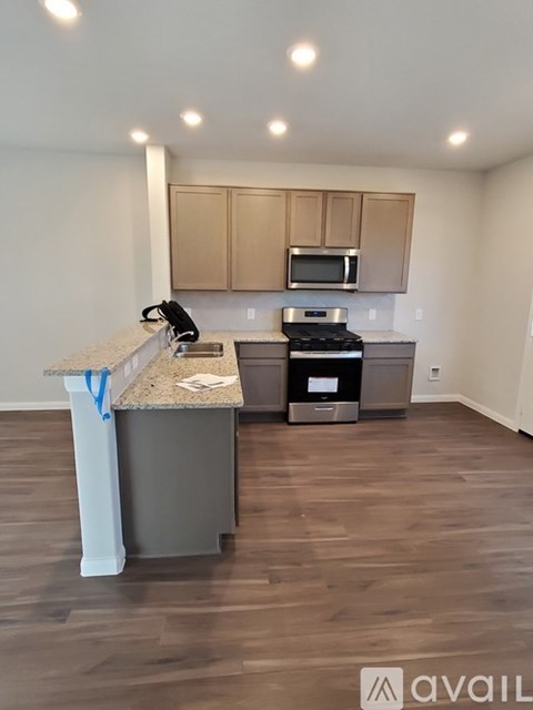 A kitchen with a granite countertop and a stove top oven.