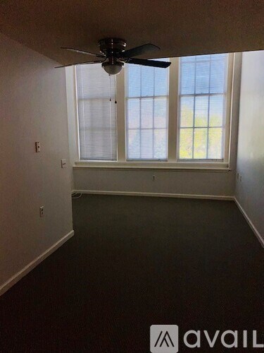 A room with a ceiling fan and a window.